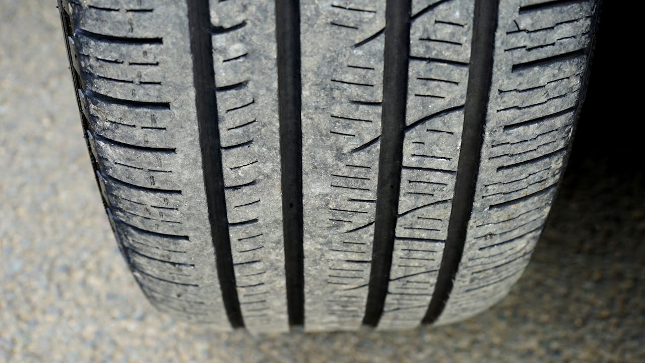 Detailed macro shot of a worn car tire tread showing wear and texture.