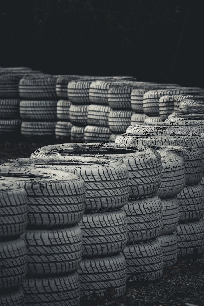 Vertical shot of stacked racing tires on a dark background for protection.
